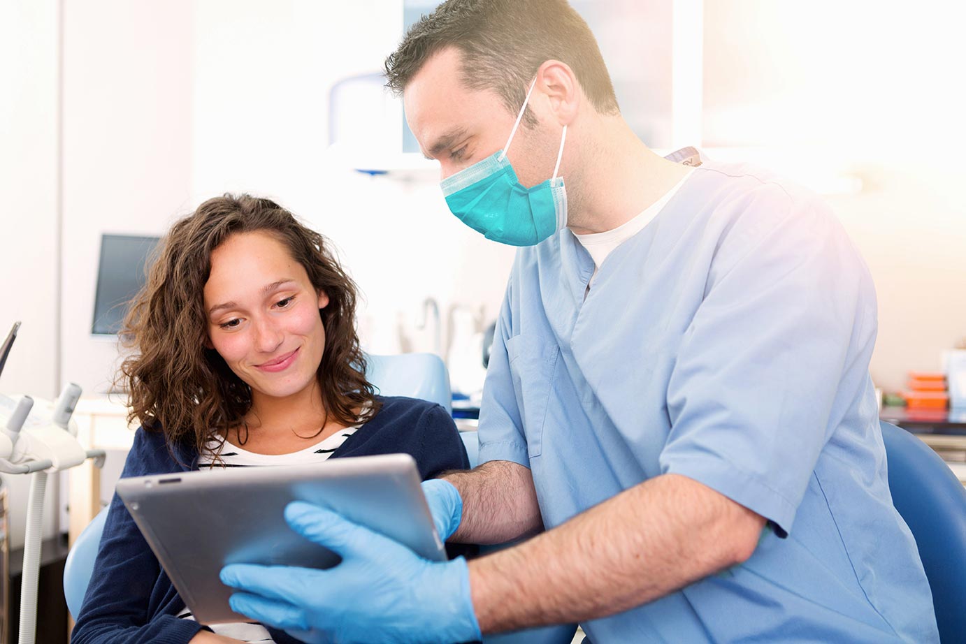 A dentist and a woman review dental X-Rays together.