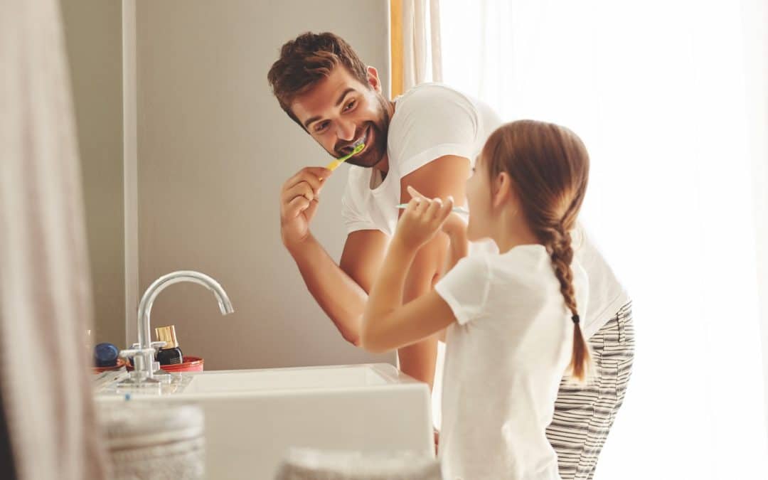 Dad and daughter brushing teeth together